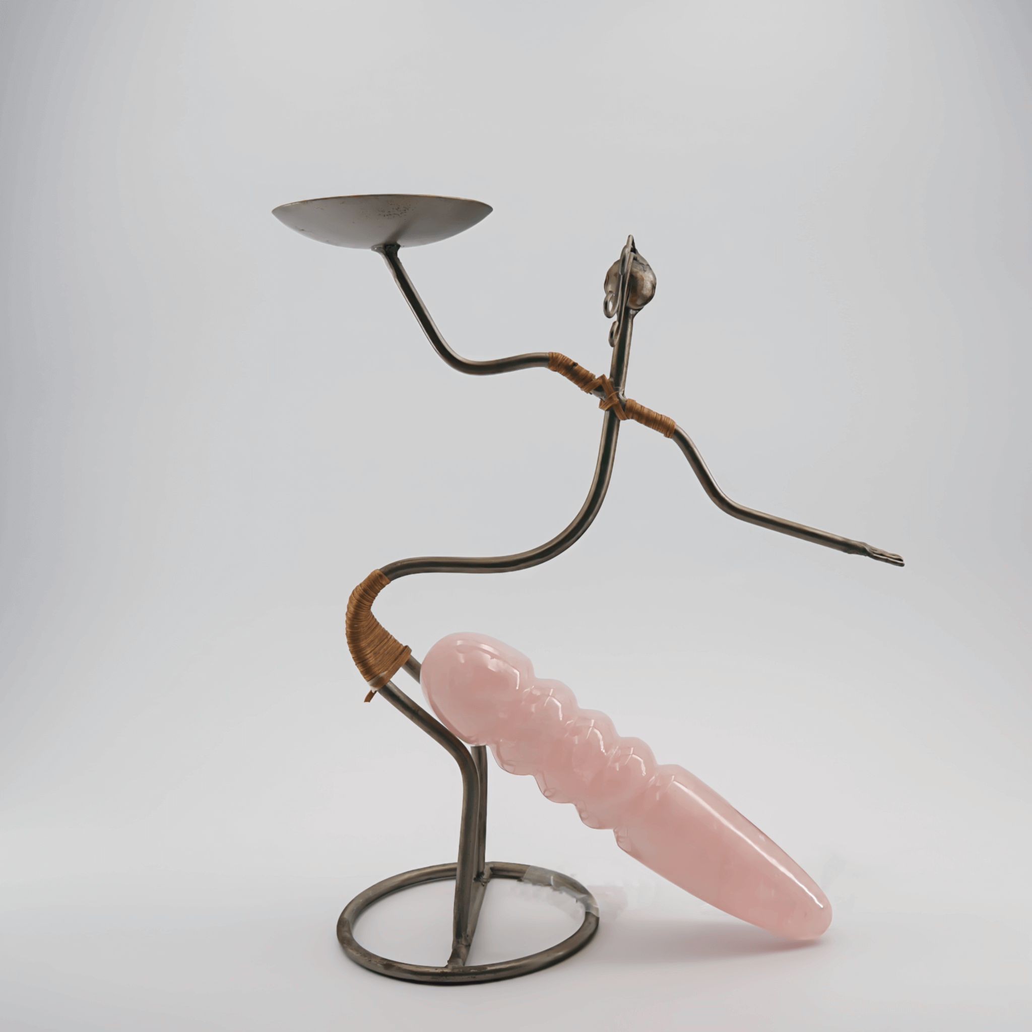 Artistic sculpture combining metal and rose quartz, representing sustainability and creativity in design.