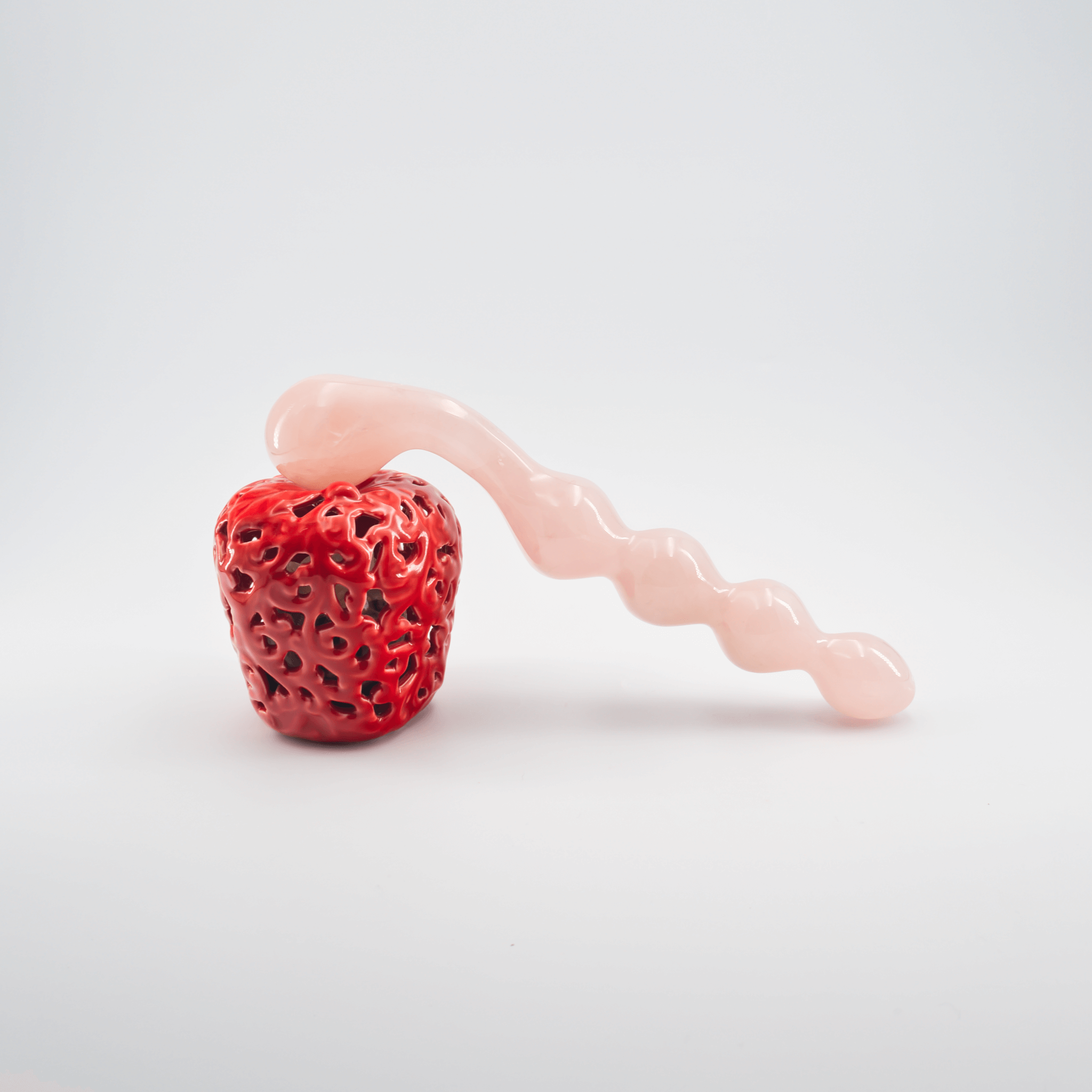 Artistic glass sculpture of a red strawberry and pink roller, showcasing intricate detailing and design.